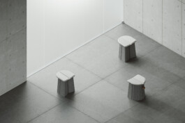 Minimalist DS-5010 Stools by Simon Busse Studio for de Sede, on gray tiles in a modern room with concrete walls. 