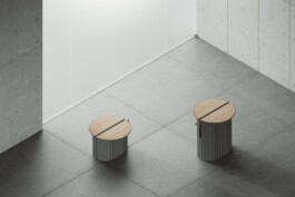 Two DS-5010 tables by Simon Busse Studio for de Sede, with wood tops and ribbed grey bases, stand in a bright, minimalist room. 