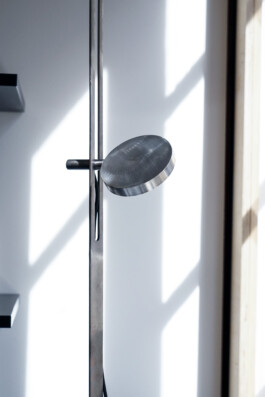 Close-up in warm light of the sleek, elegant “Echo” floor lamp by Simon Busse for caussa, made of aluminum.
